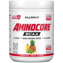 A white plastic tub of Allmax Aminocore BCAA powder in Tropical Fruit Punch flavor, featuring a white label with red and black text and fruit illustrations of pineapple, banana, and kiwi.