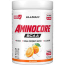 A white plastic tub of Allmax Aminocore BCAA powder supplement, featuring a white label with bold red and black text, orange fruit graphics, and an orange flavor label at the bottom.
