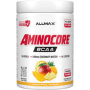 A white plastic tub of Allmax Aminocore BCAA powder in Pineapple Mango flavor, featuring red and black text and fruit illustrations on the label.