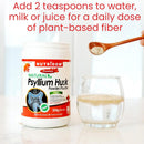 A white tub of NutriDom Natural Psyllium Husk powder stands on a light countertop beside a clear glass of mixed powder and water, with a wooden spoon holding more powder above. Red text at the top reads, 'Add 2 teaspoons to water, milk or juice for a daily dose of plant-based fiber.