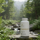 Vital Life Magnesium supplement bottle in a natural setting with a stream and trees.